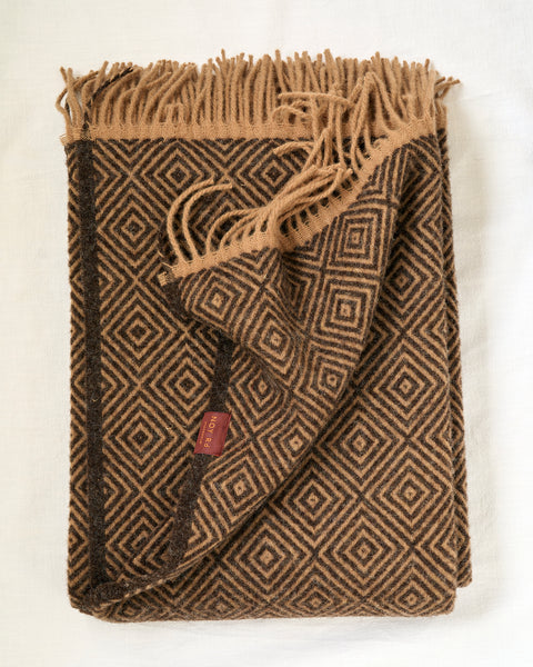 Brown patterned blanket with fringes on a white background