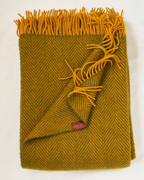 Mustard herringbone patterned throw blanket with fringes on a white background