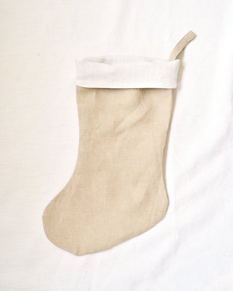 Beige Christmas stocking with white cuff on a white background