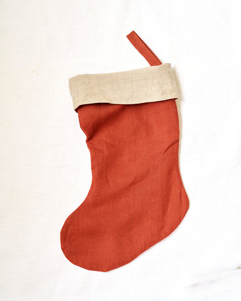 Red Christmas stocking with beige trim on a white background